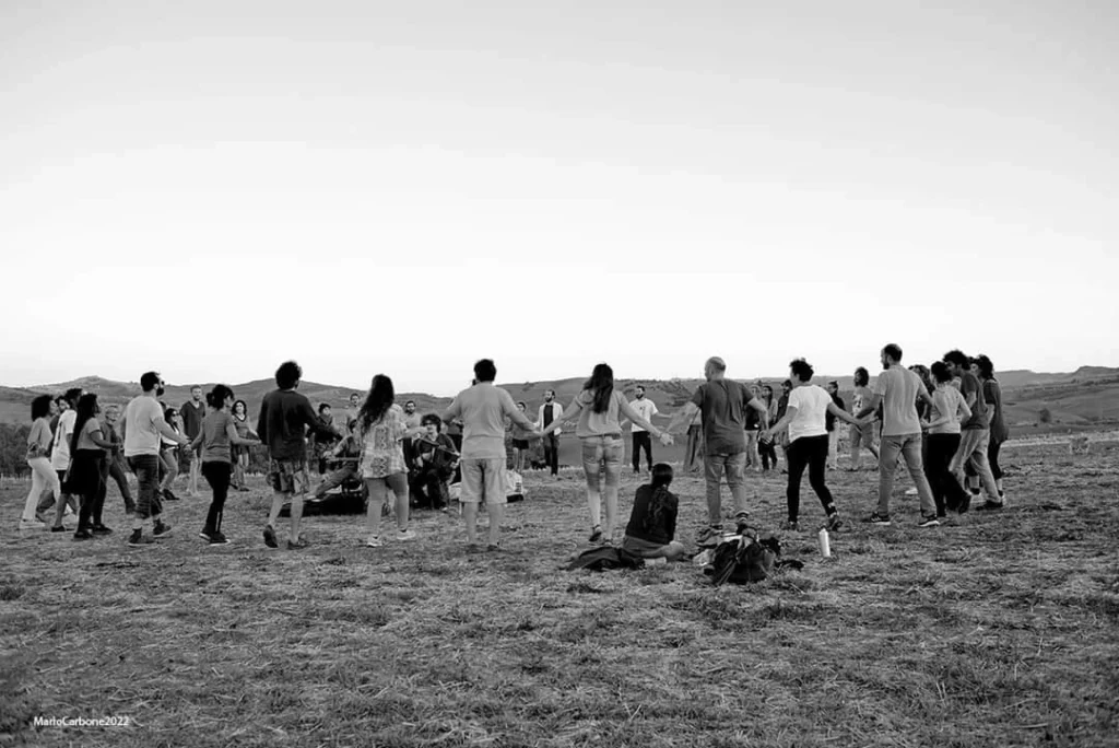 foto di una danza in aperta campagna, in circolo, al suono dell'organetto