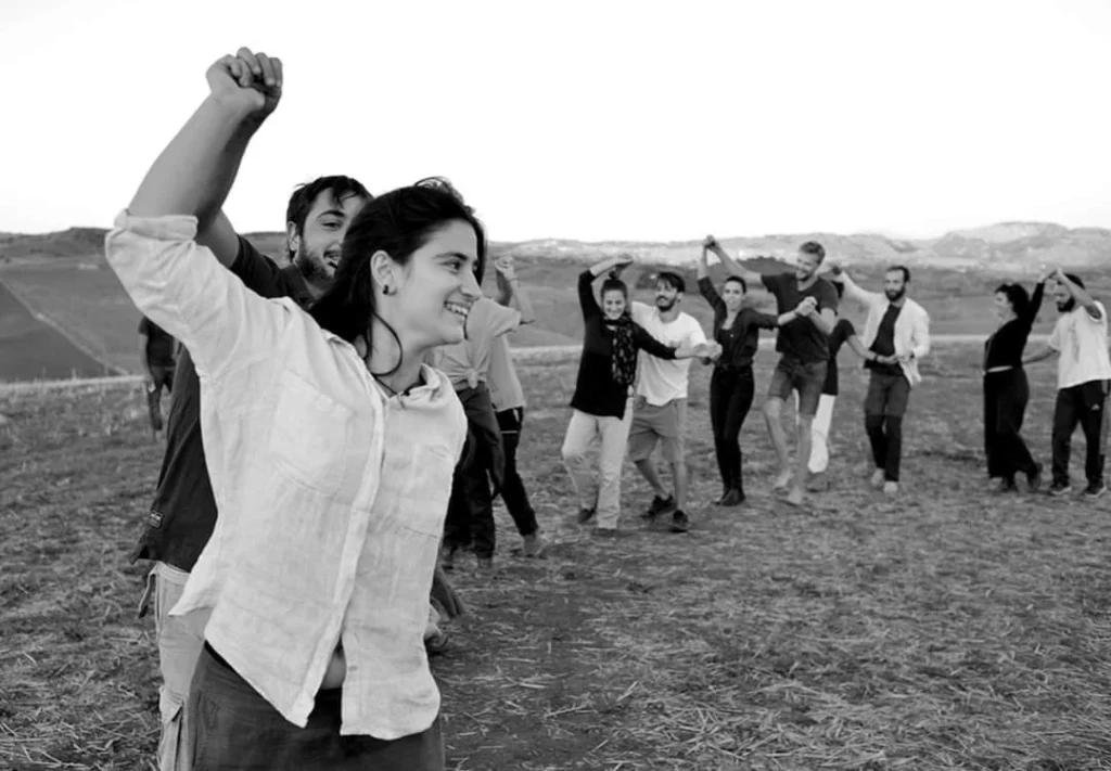 foto di una danza in aperta campagna, in circolo, al suono dell'organetto