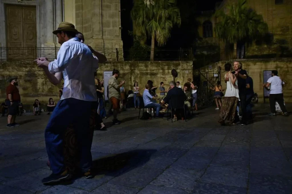 foto di una danza in piazza al suono dell'organetto, di notte.
